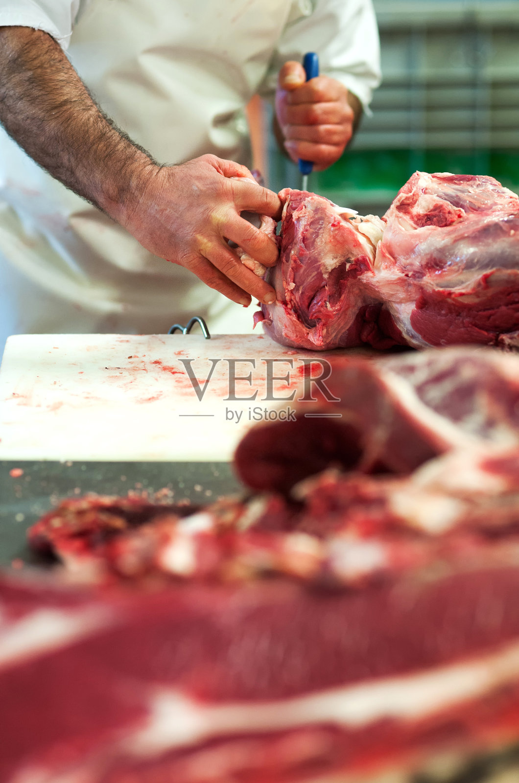 屠夫在屠宰场切生肉照片摄影图片