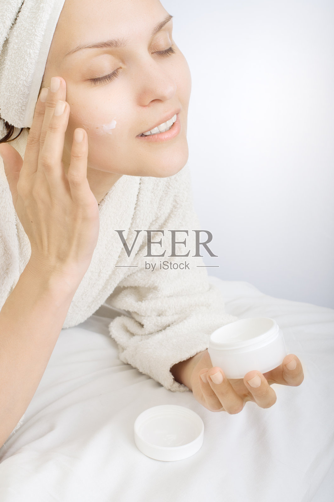 美丽的女人使用面部克里姆照片摄影图片