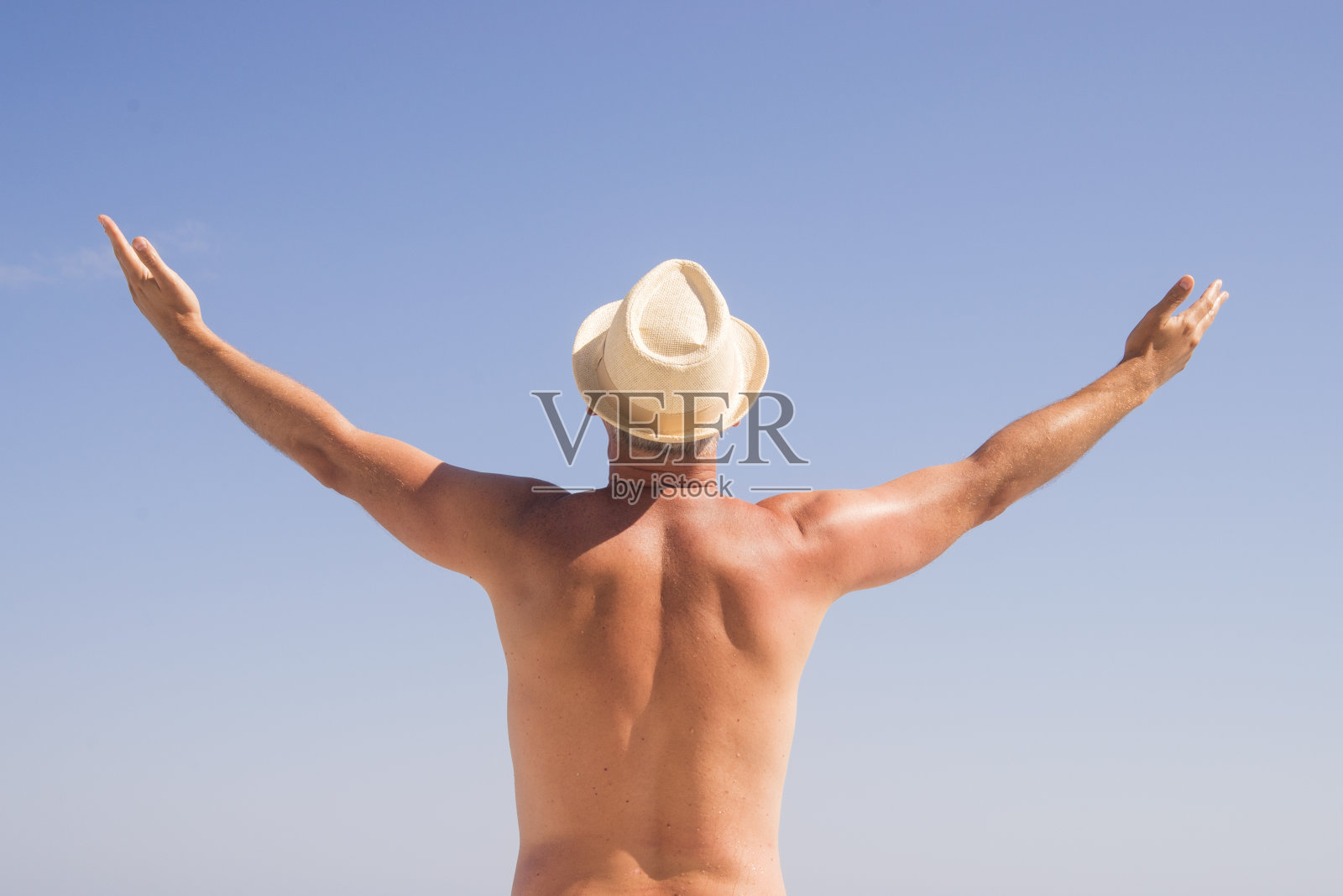 男人张开双臂向后站,望着大海照片摄影图片