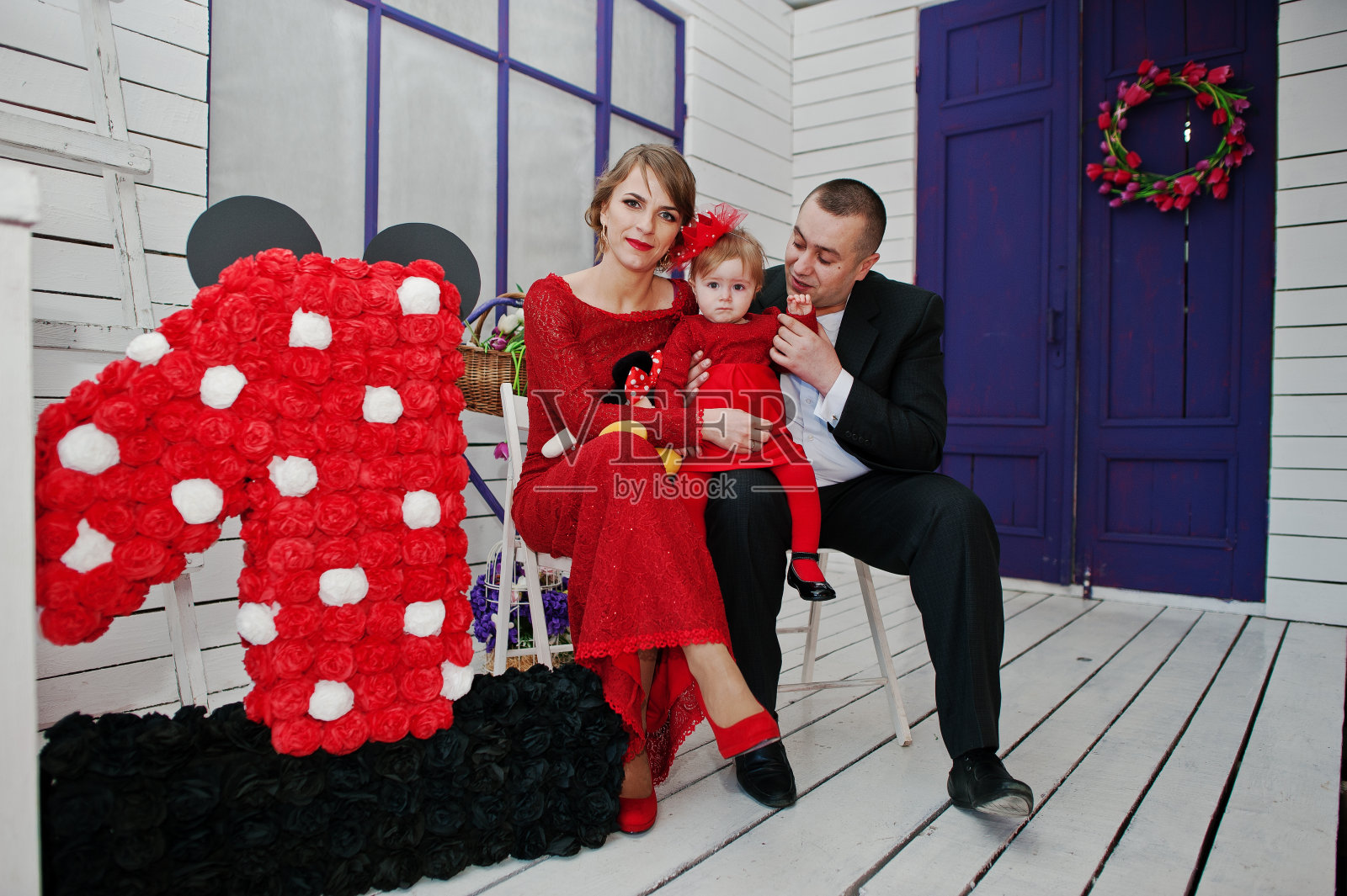 幸福的家庭和女儿坐在椅子旁边装饰,背景是白色和紫色的木制房间照片摄影图片