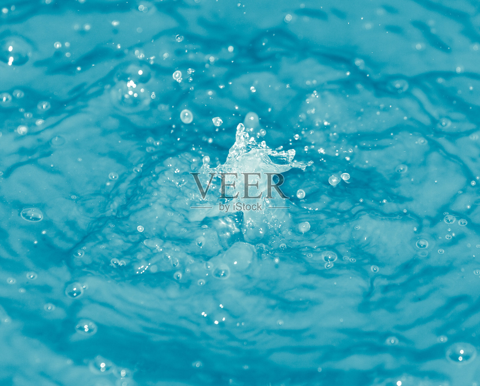 水滴落进蓝色的水里照片摄影图片