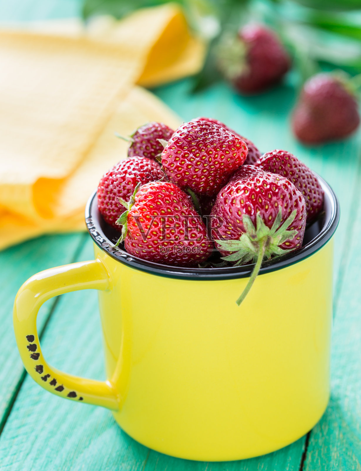 黄色杯子里装着新鲜草莓照片摄影图片