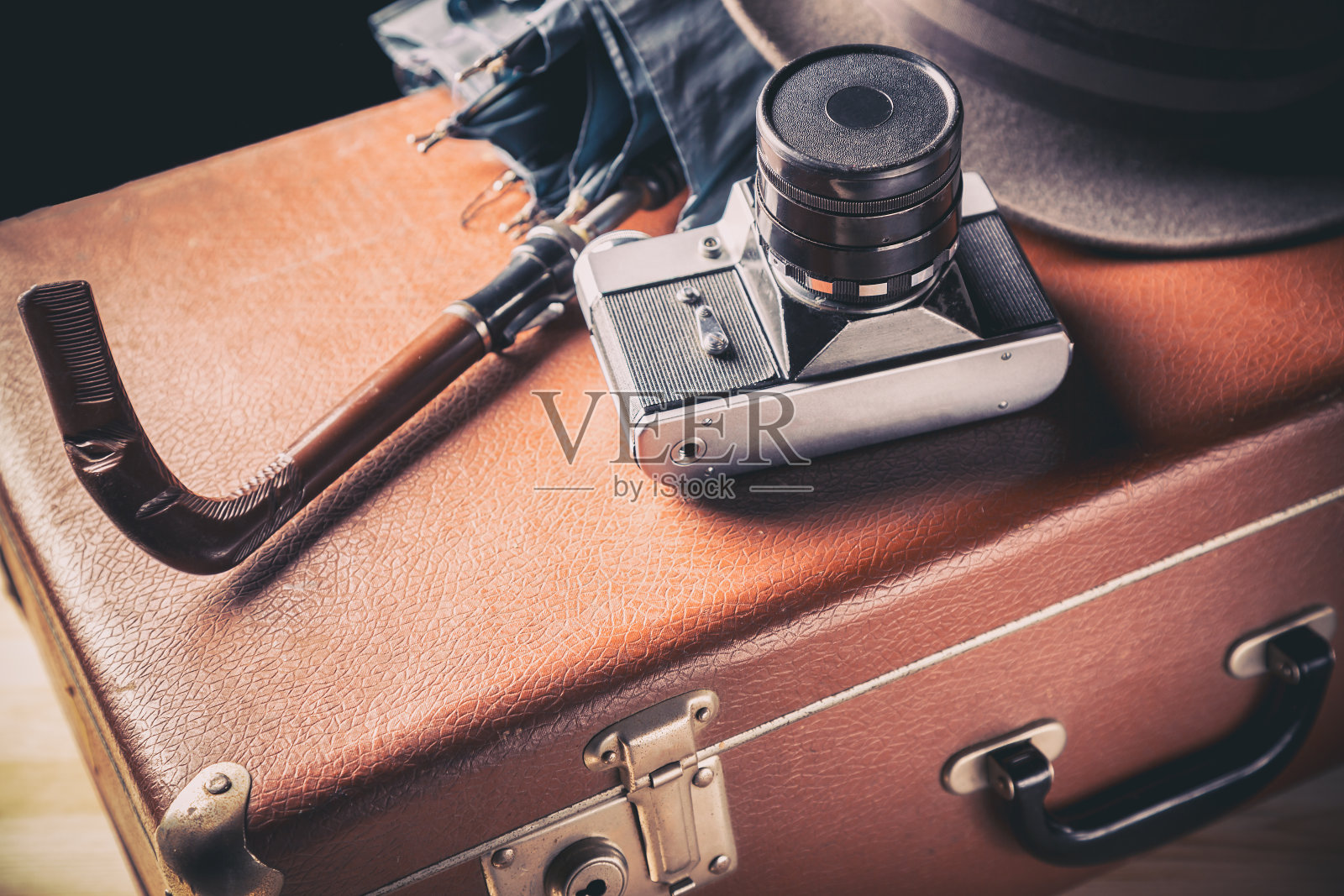 冒险的概念。老式胶卷相机,老式帽子和雨伞,棕色行李箱。复古的照片摄影图片