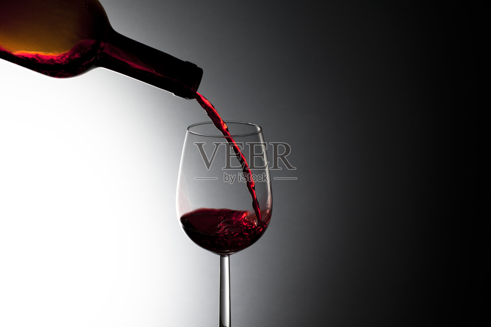 把红酒倒进玻璃杯里,特写照片摄影图片