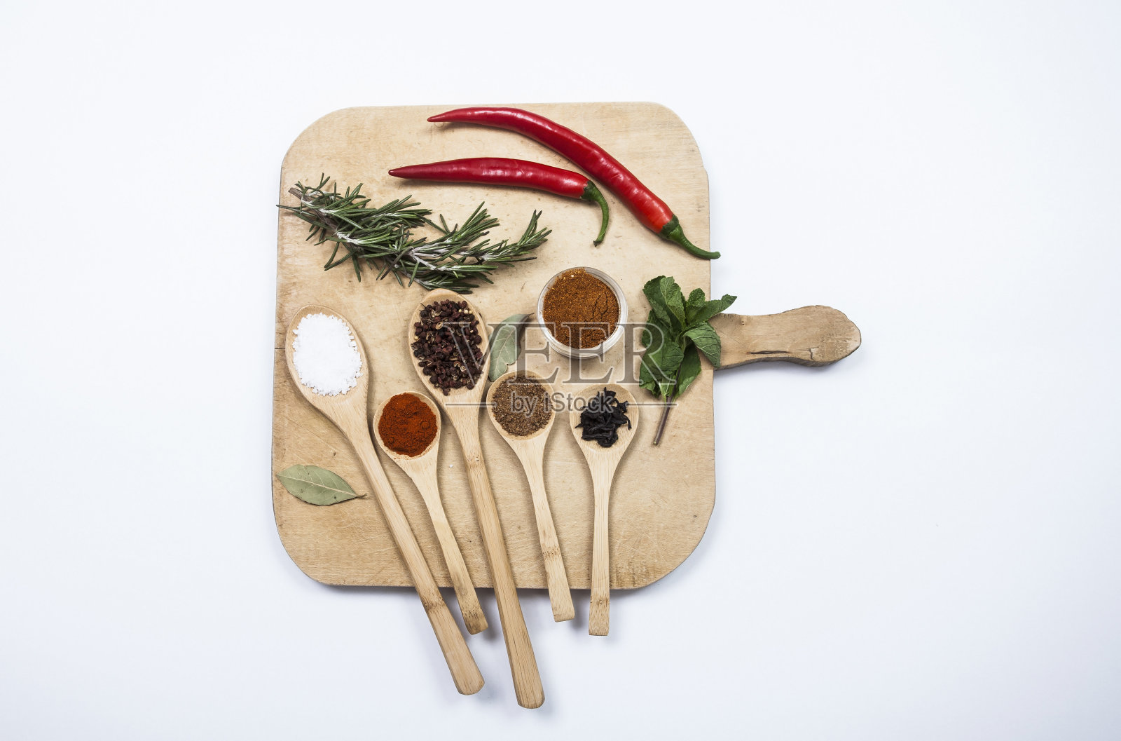 切菜板上放五颜六色的香料和勺子照片摄影图片