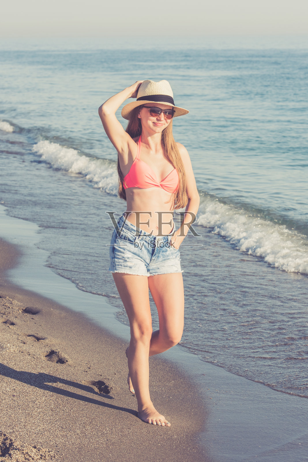 一个年轻女子在海滩上散步照片摄影图片