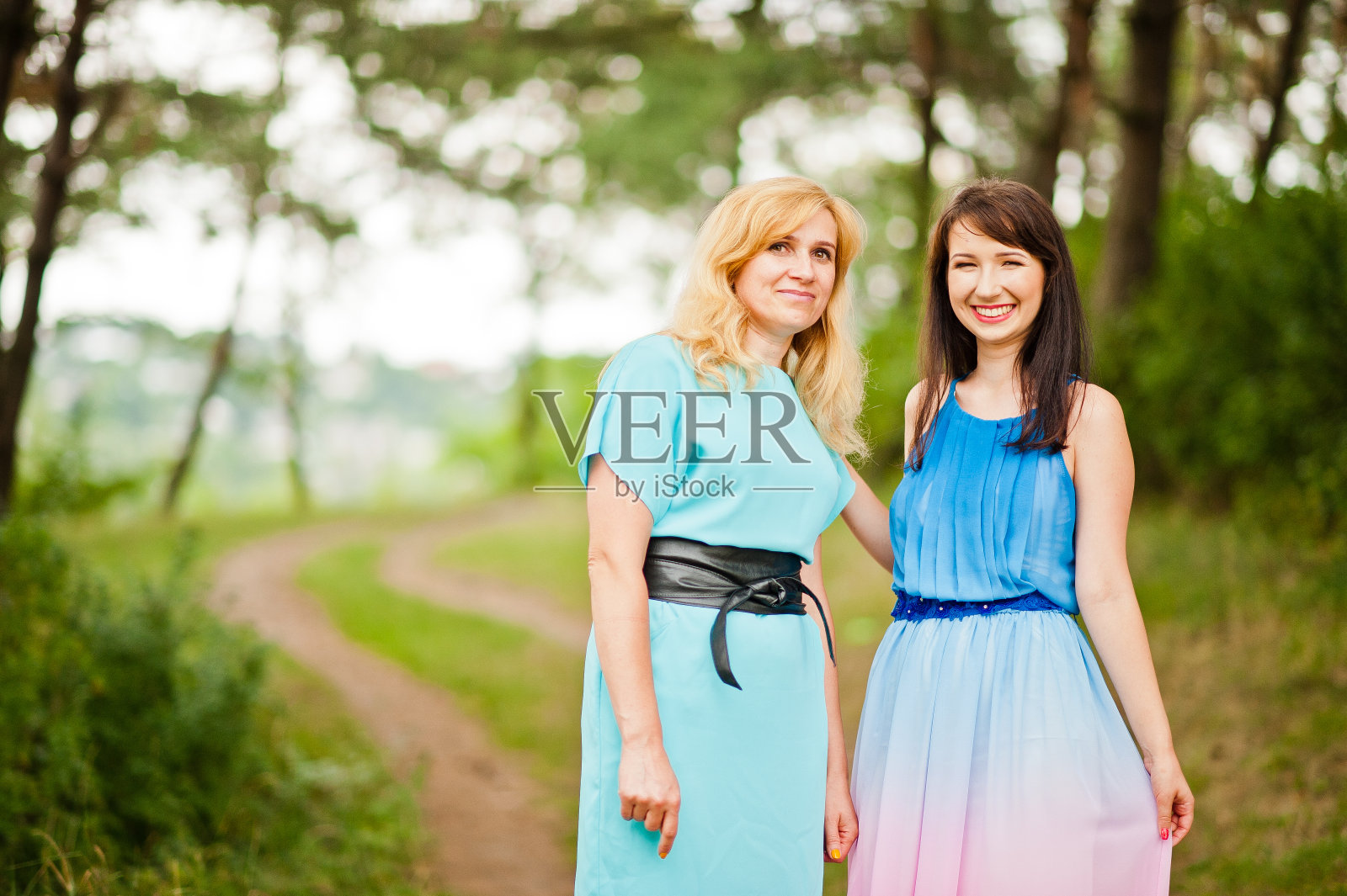 幸福的家庭。年轻的母亲和女儿在松树林照片摄影图片