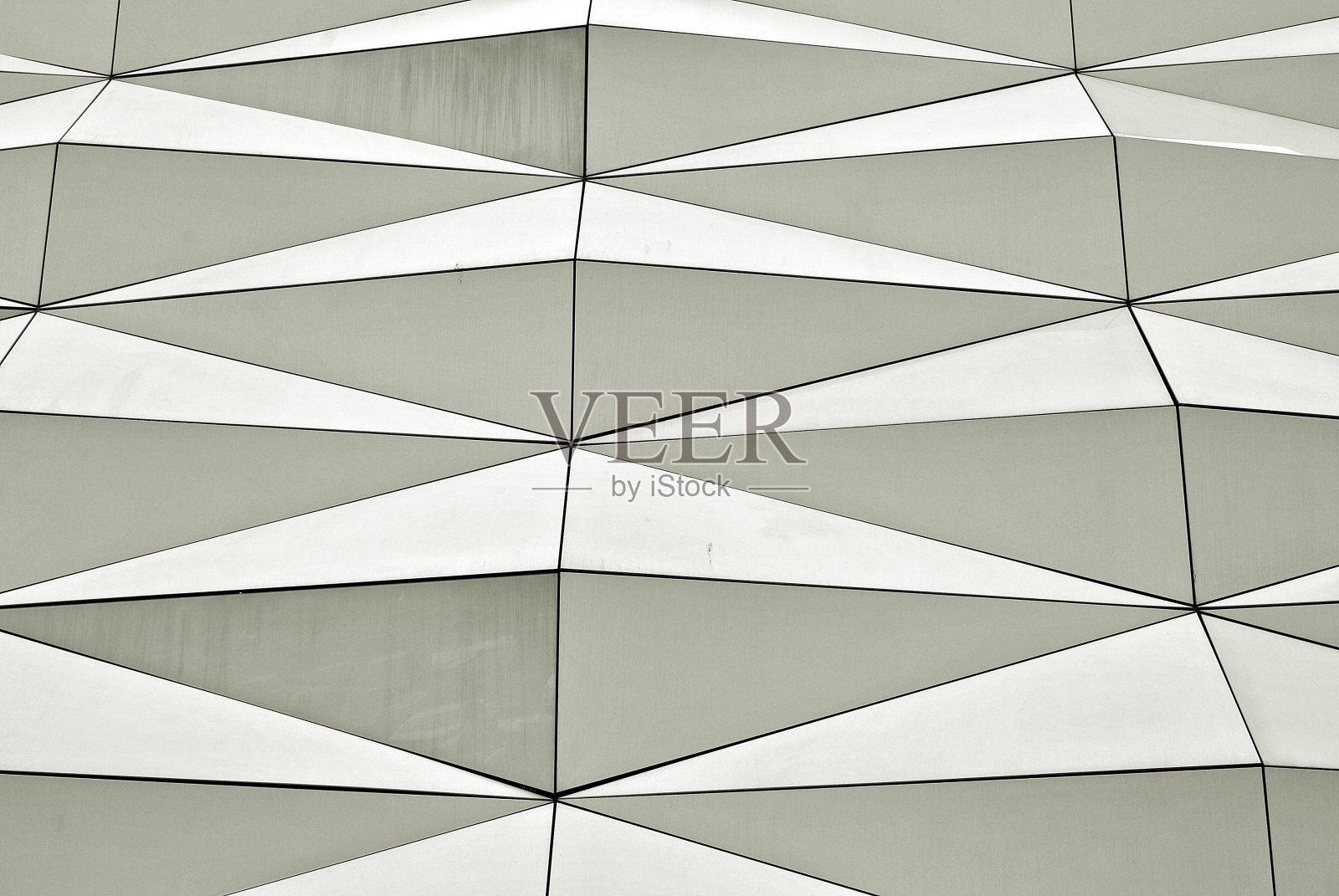 现代建筑的多边形三角形玻璃立面。照片摄影图片