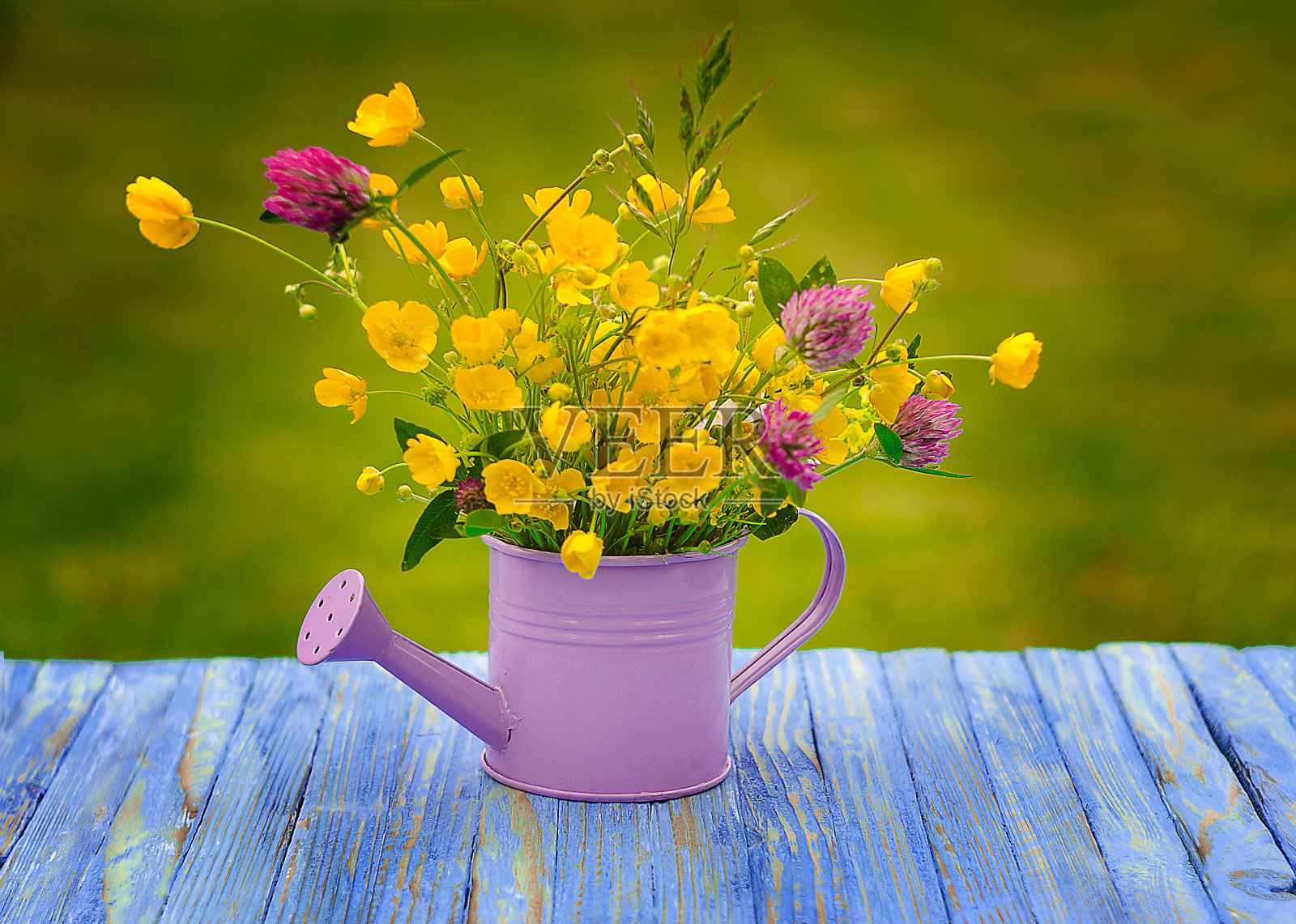 户外花瓶里放着一束不同颜色的野花照片摄影图片