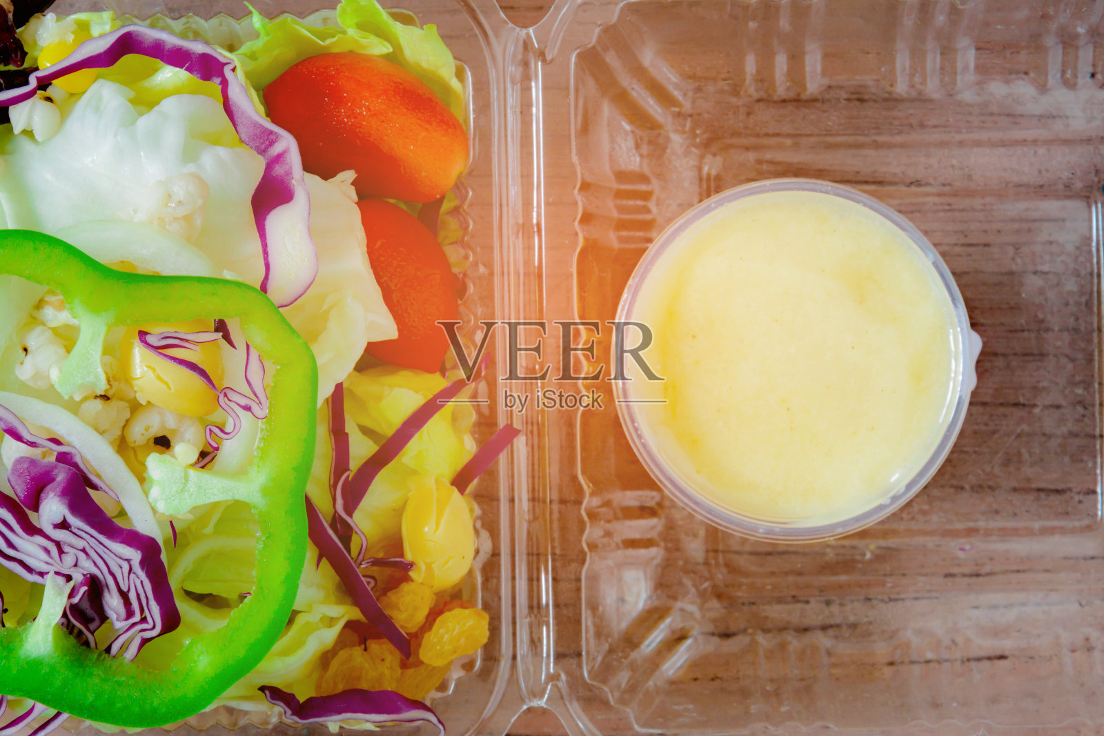 沙拉装在旧木箱上的塑料盒子里照片摄影图片