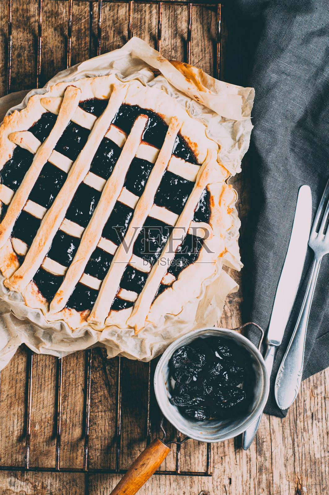 旧木桌上的烤架上放着葡萄干派照片摄影图片