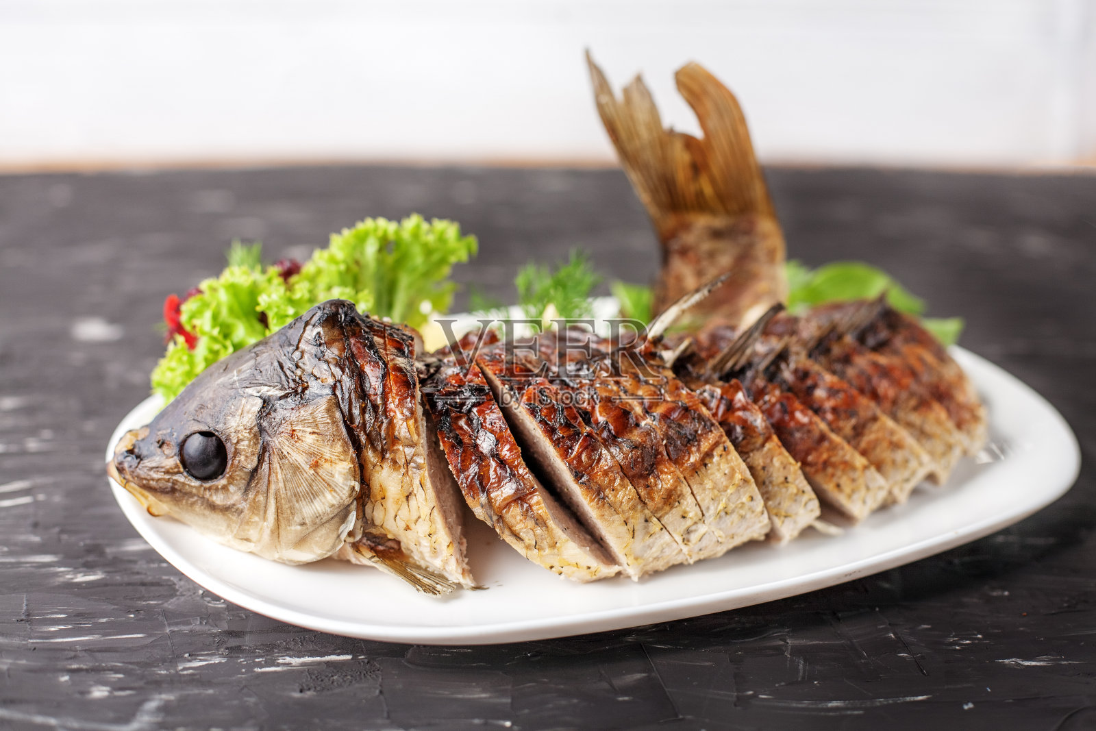 塞满生菜,胡椒和柠檬的鱼。食物和餐厅的概念。照片摄影图片