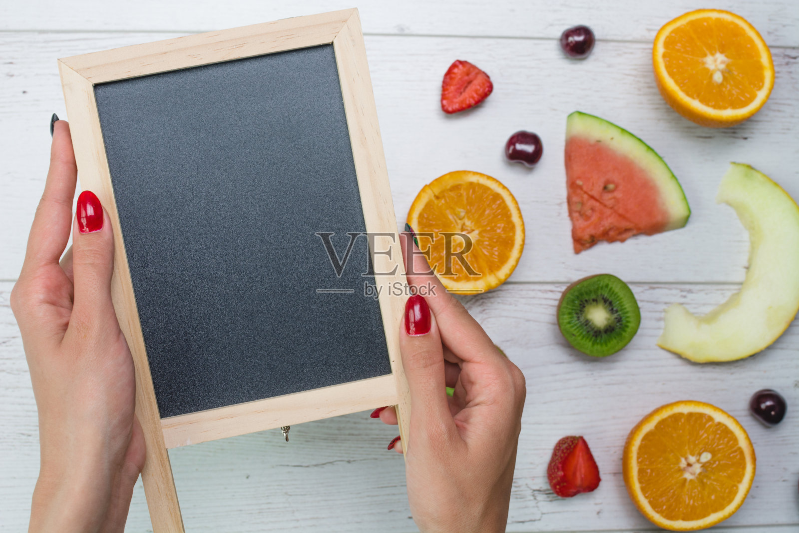 俯视图的女孩的手,放在白色的桌面与水果照片摄影图片