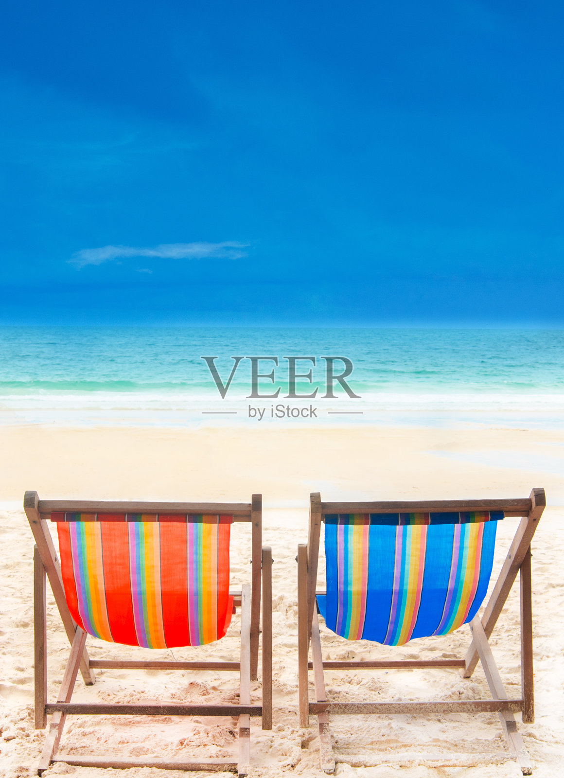 白色沙滩上的两把彩色沙滩椅照片摄影图片