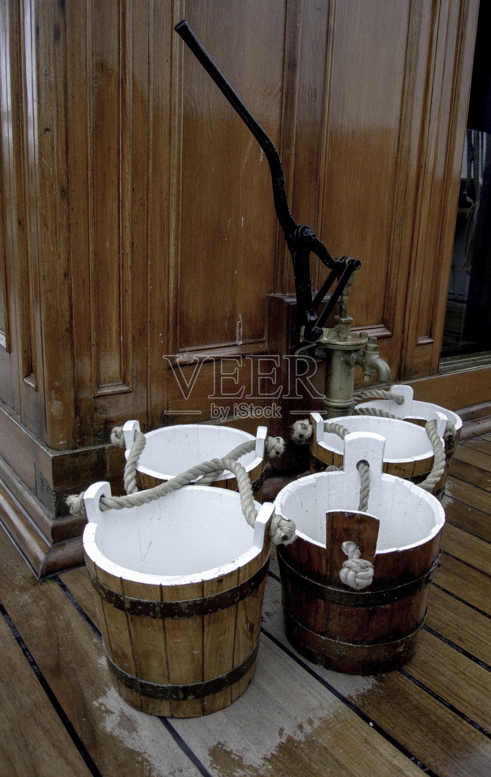 船上的老式水桶和水泵。照片摄影图片