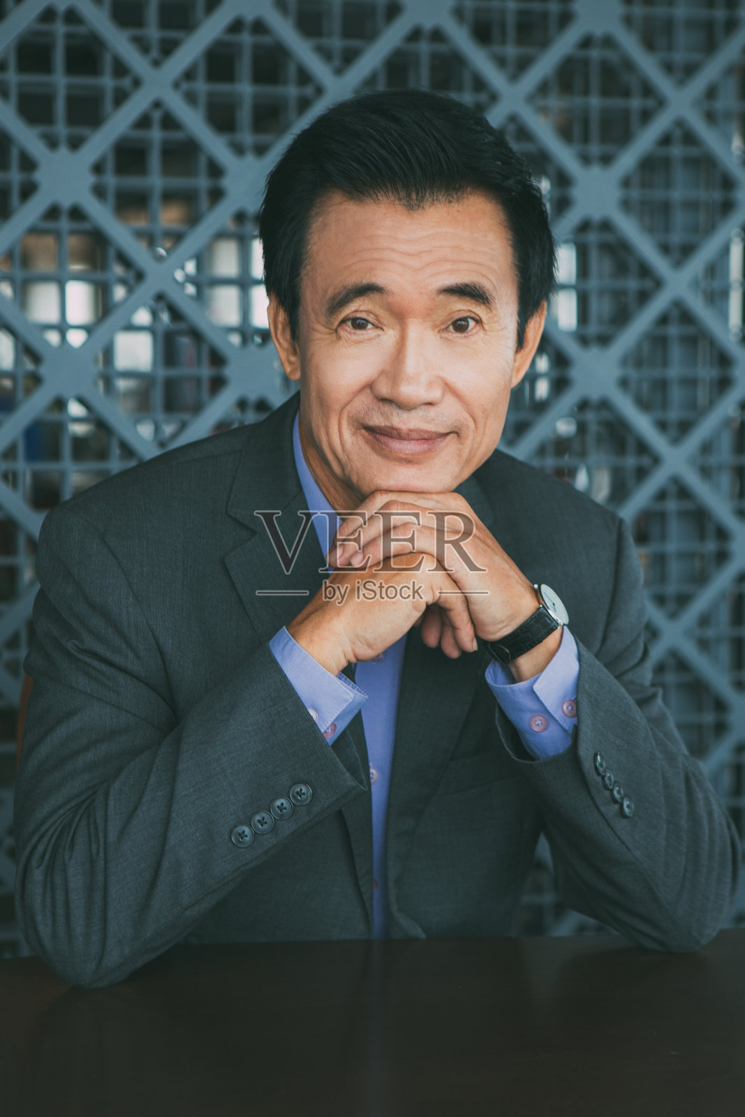 微笑的亚洲男人手放在下巴的肖像照片摄影图片