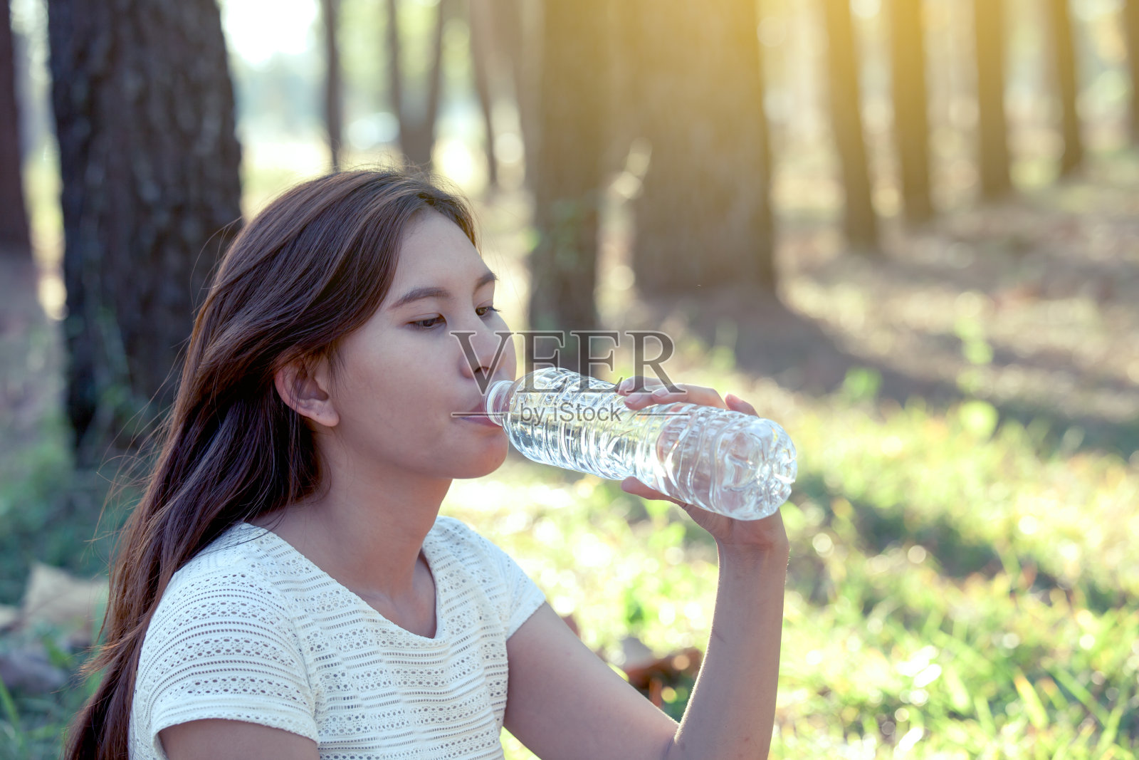 年轻的亚洲女人在自然公园里喝水照片摄影图片