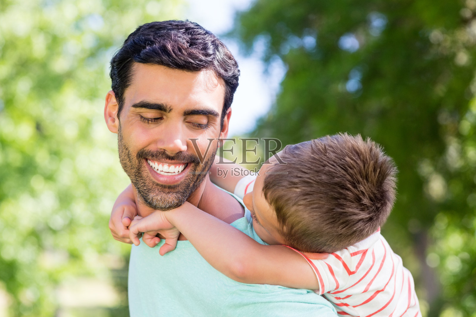 快乐的父亲让他的儿子骑在背上照片摄影图片