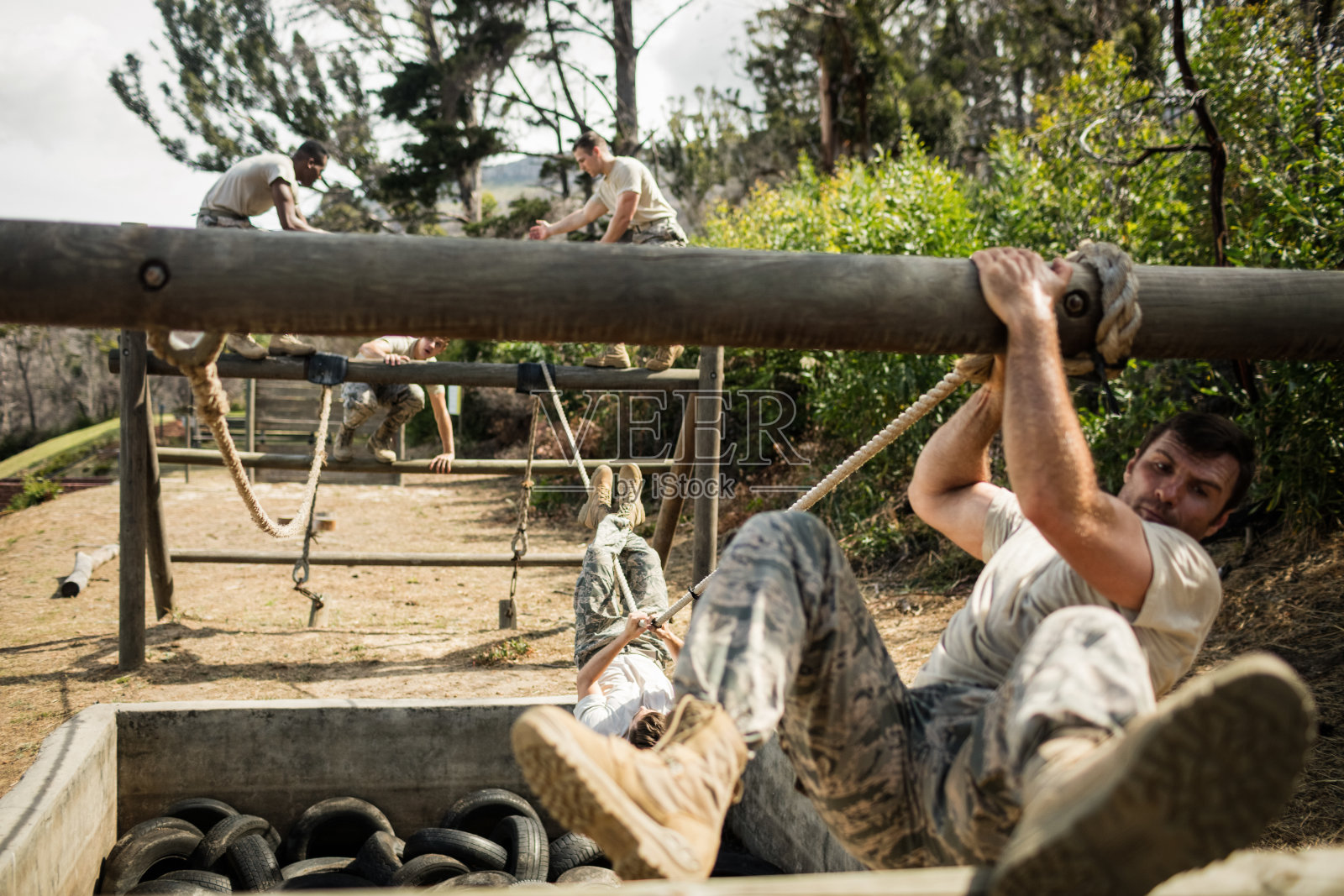 年轻的军人在障碍训练场练习攀绳照片摄影图片
