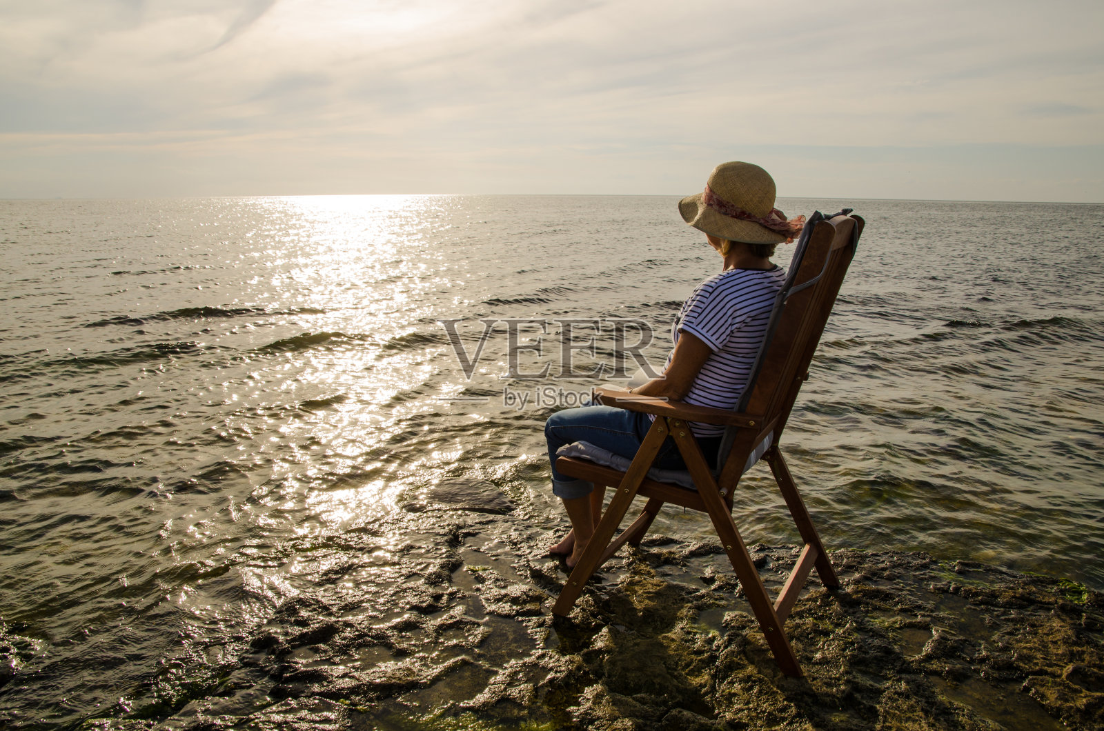 坐在靠近水的地方照片摄影图片