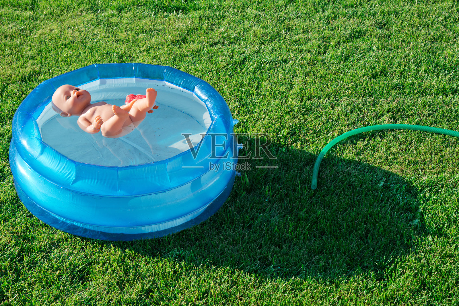 娃娃漂浮在小水池里照片摄影图片