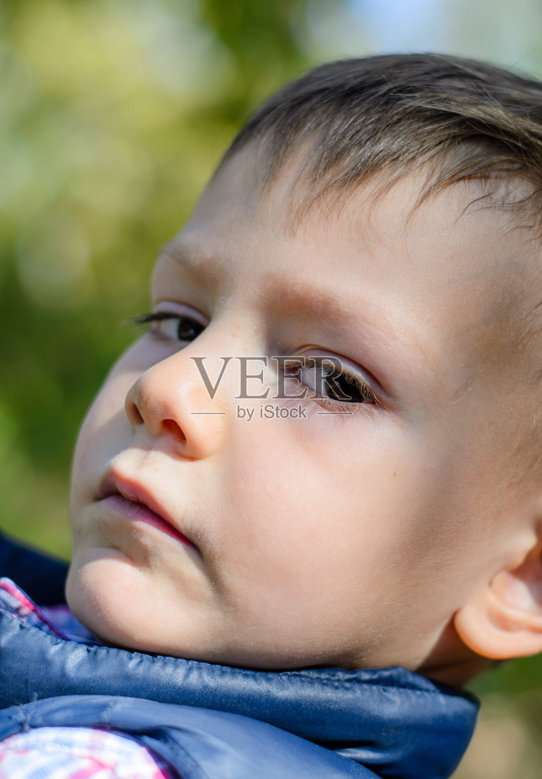 严肃的户外小男孩的特写照片摄影图片