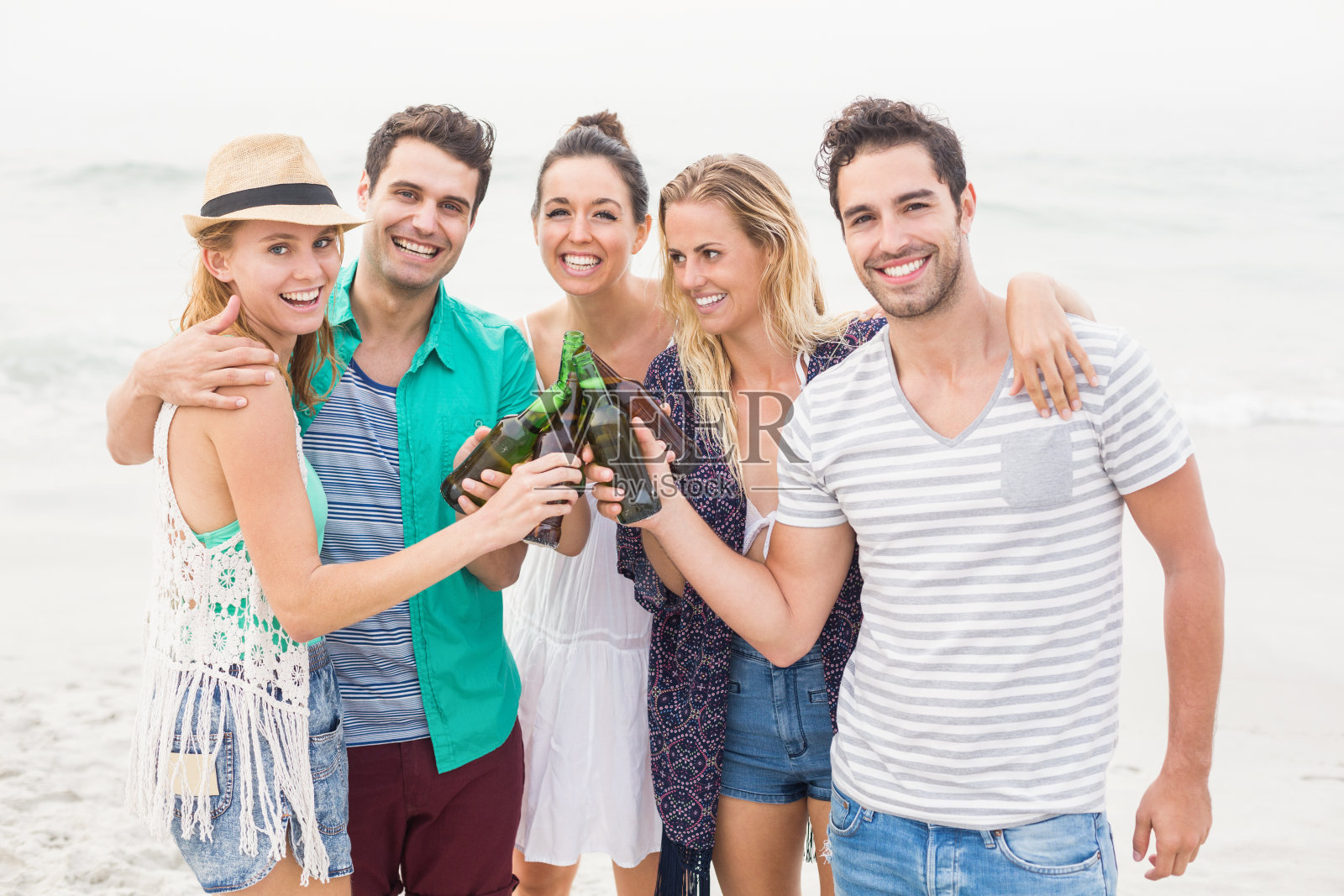 一群朋友在海滩上喝啤酒瓶照片摄影图片