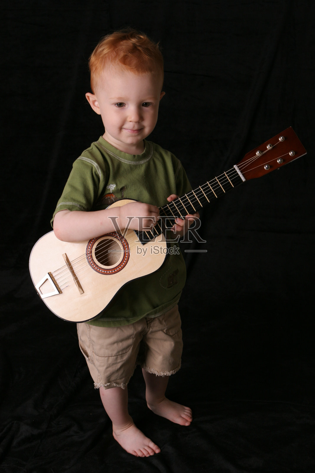 吉他小子在黑满上照片摄影图片