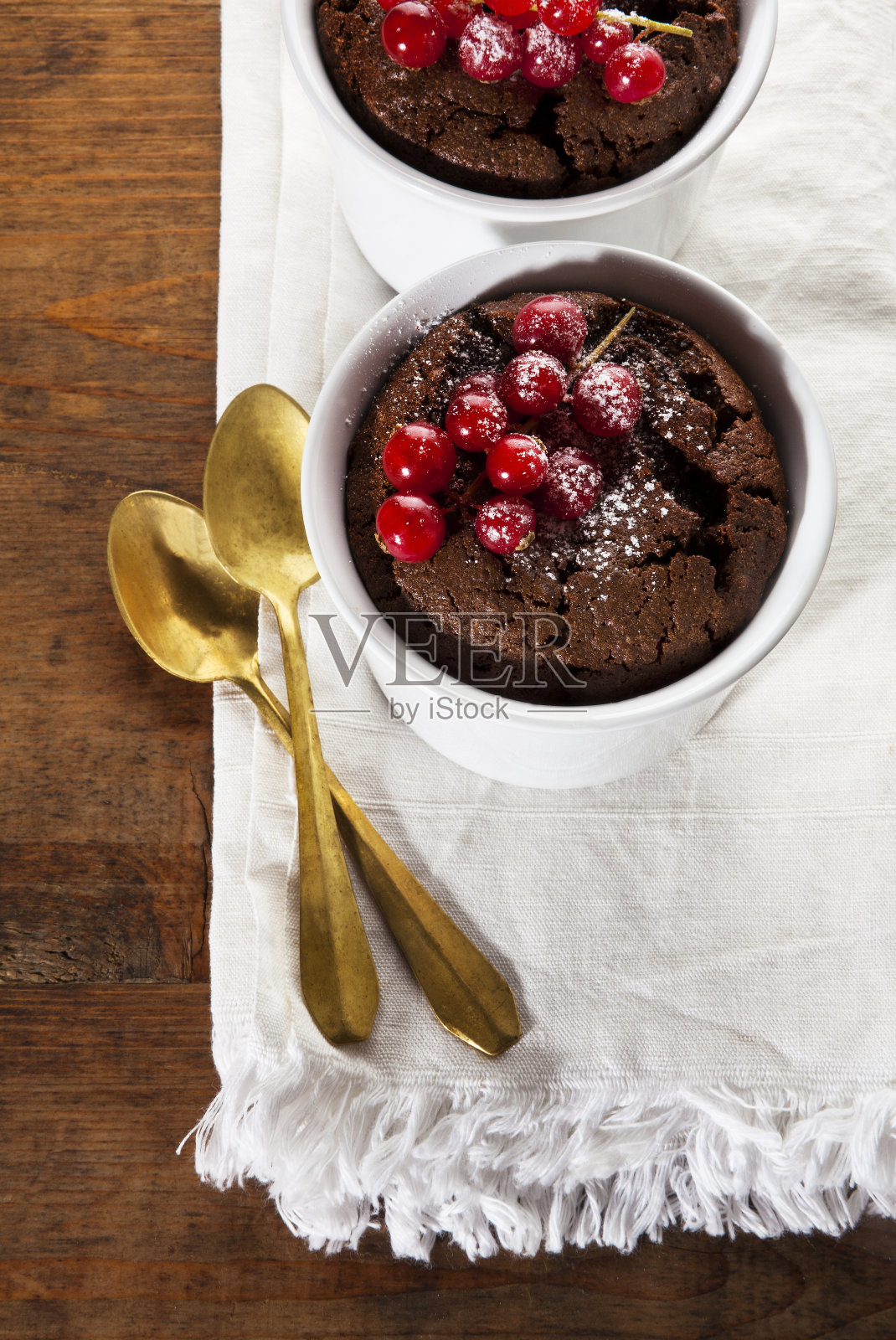 木桌上放着巧克力烤布丁。健康的照片摄影图片