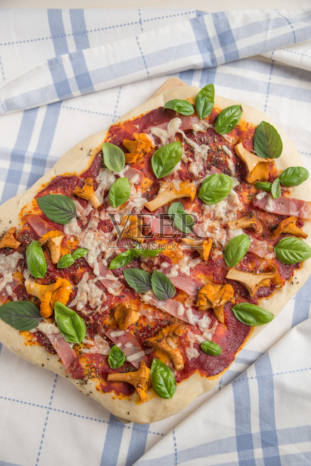 鸡油菌、培根和芝麻菜的披萨照片摄影图片