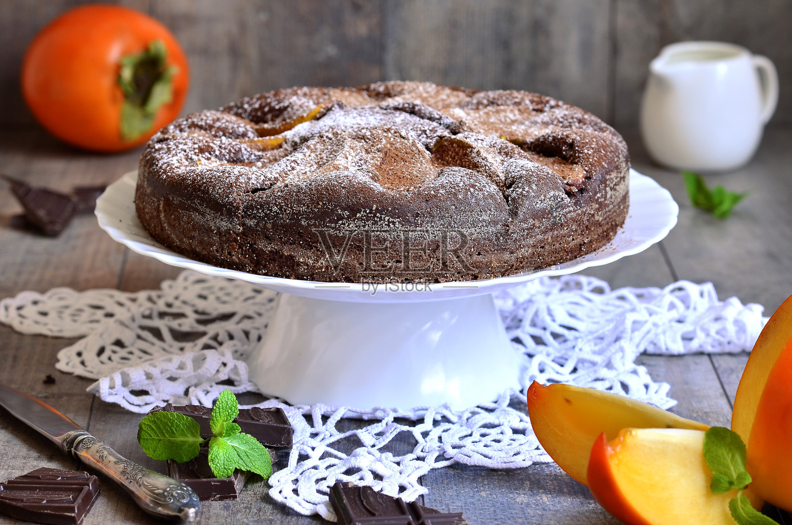 巧克力蛋糕配柿子。照片摄影图片