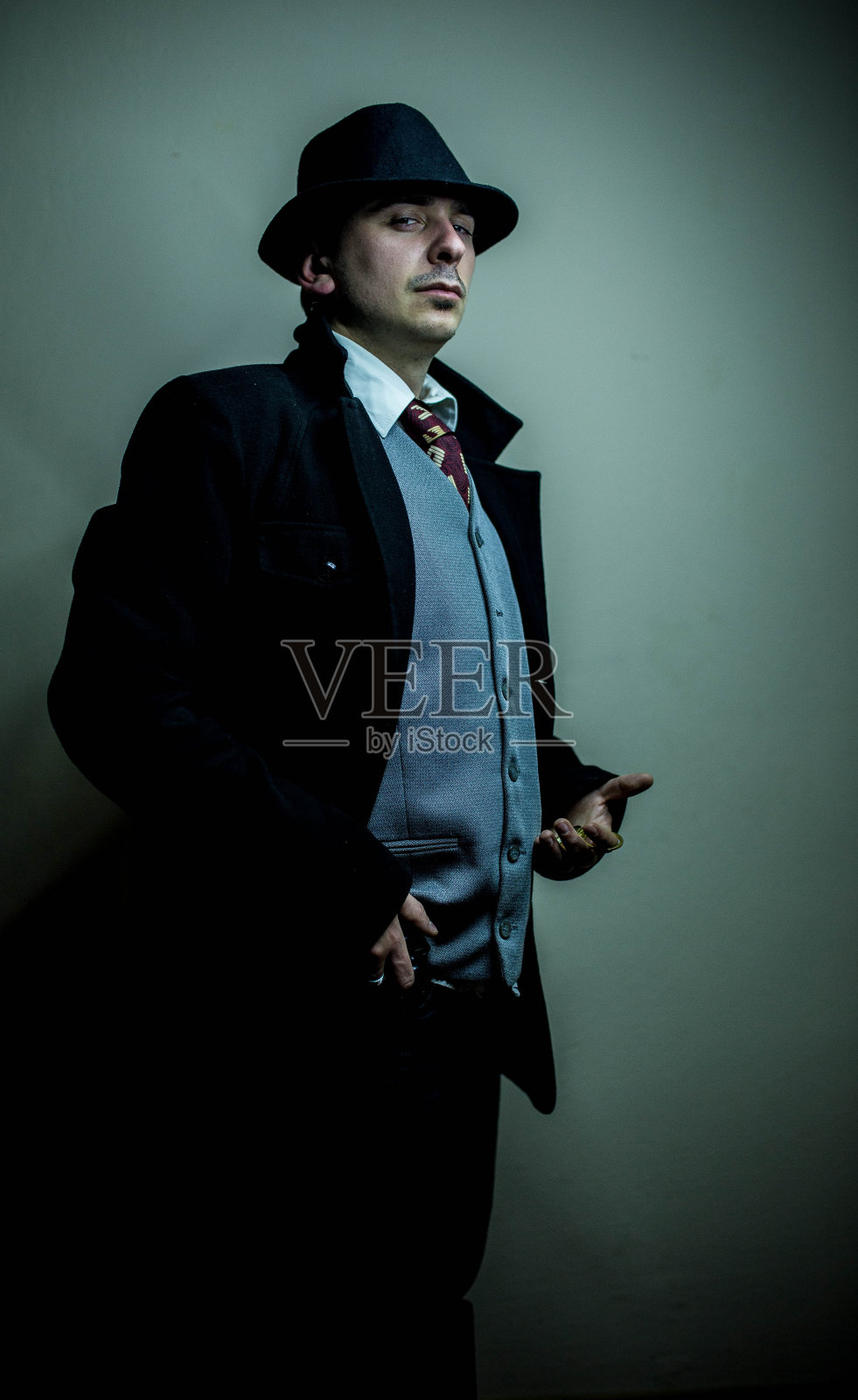 拿着手表的严肃侦探照片摄影图片