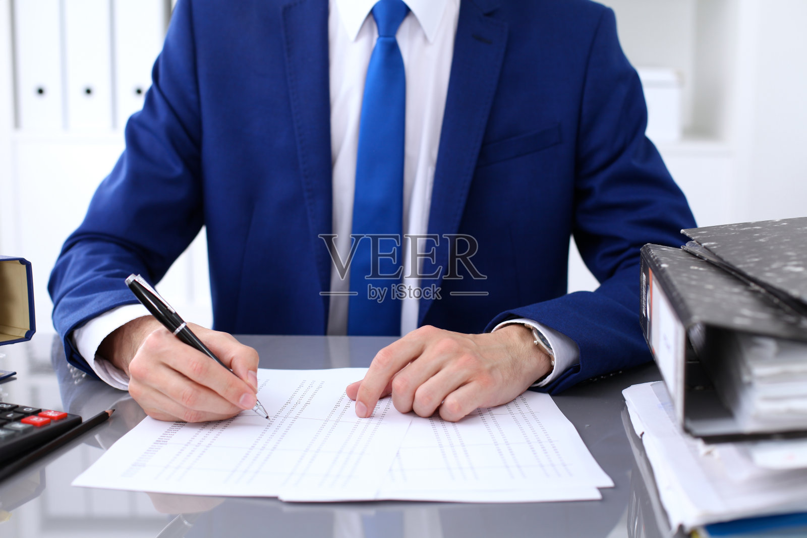 密切查看簿记员或财务检查手的报告,计算或检查余额。美国国税局稽查员检查财务文件。照片摄影图片