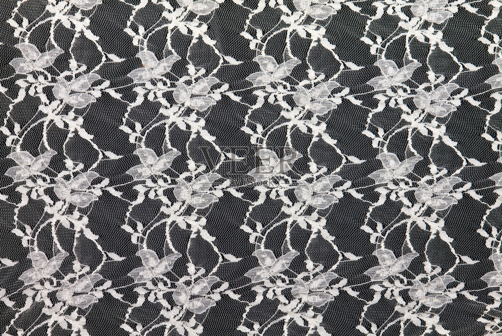 黑色背景上的白色蕾丝。照片摄影图片