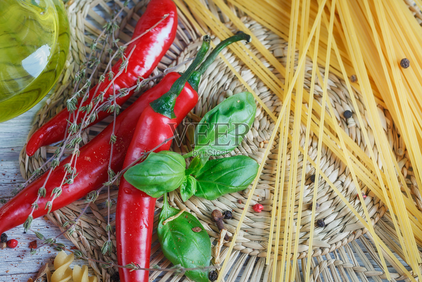 以意大利食物为背景,有番茄,罗勒,意大利面,橄榄油,花椒,辣椒和百里香。照片摄影图片
