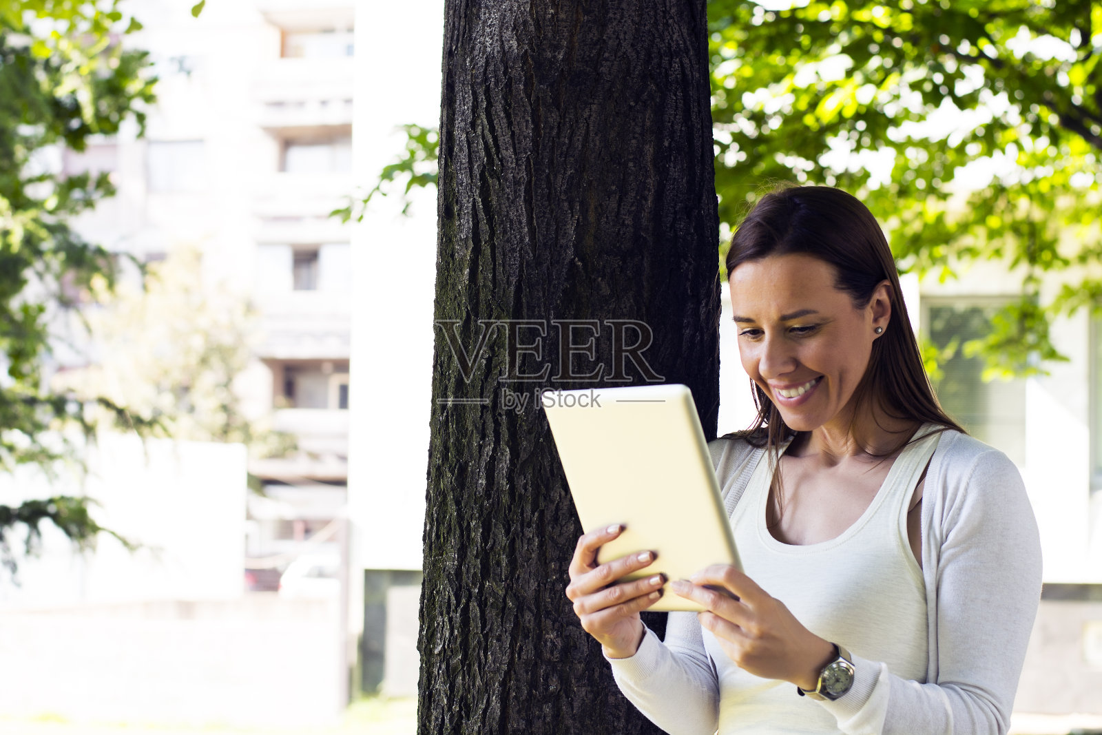 年轻女子在公园里使用平板电脑照片摄影图片
