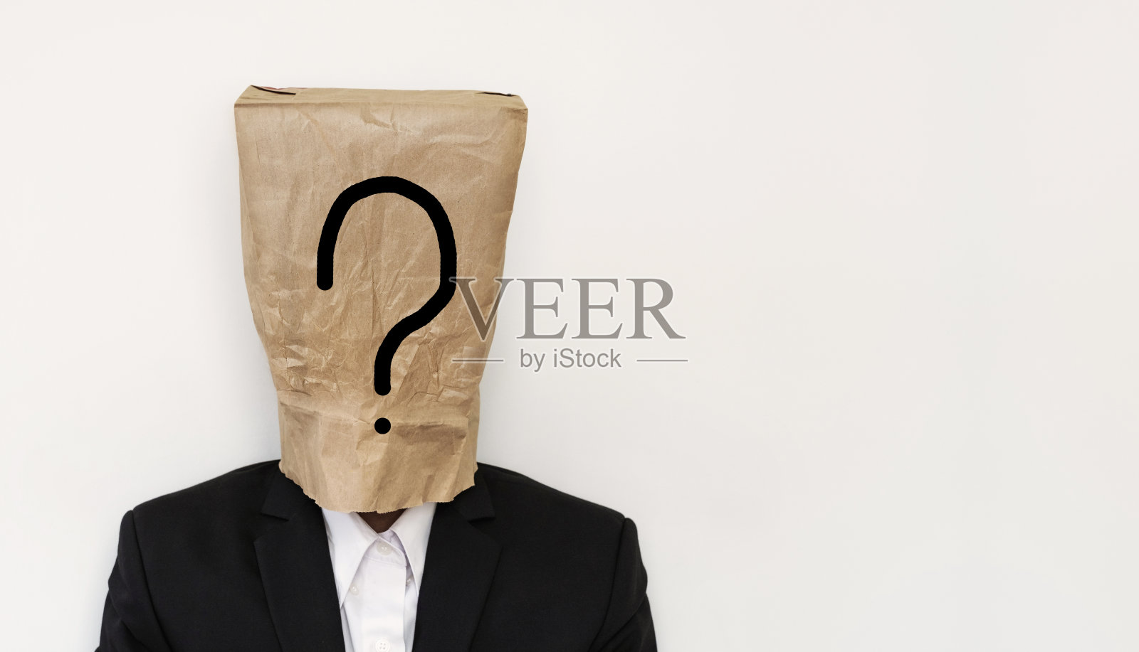 商人头戴棕色纸袋,带问号照片摄影图片