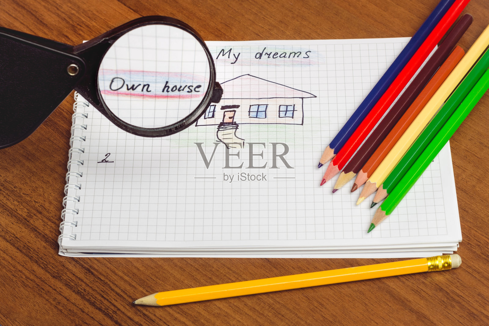 我的梦想自己的房子写文字和画在记事本上,彩色铅笔在桌子上。可视化未来的概念。照片摄影图片
