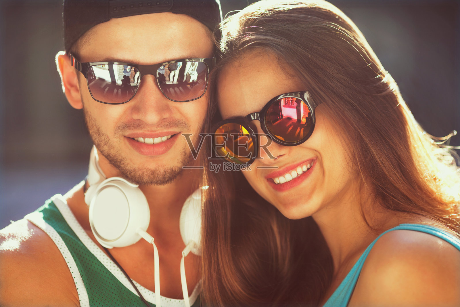 时尚情侣戴着太阳镜在墙上涂鸦照片摄影图片