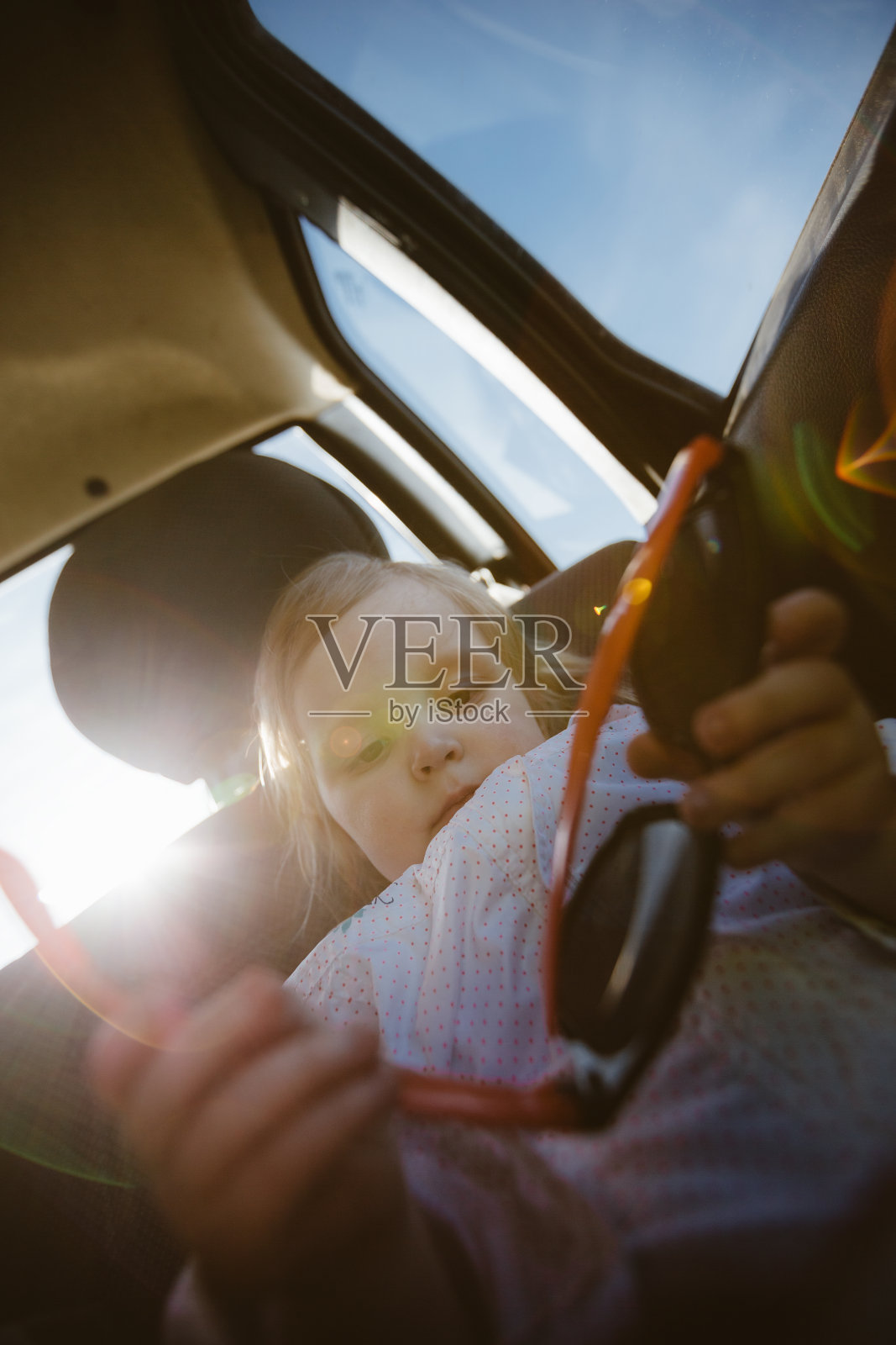 车里有个戴墨镜的小女孩照片摄影图片