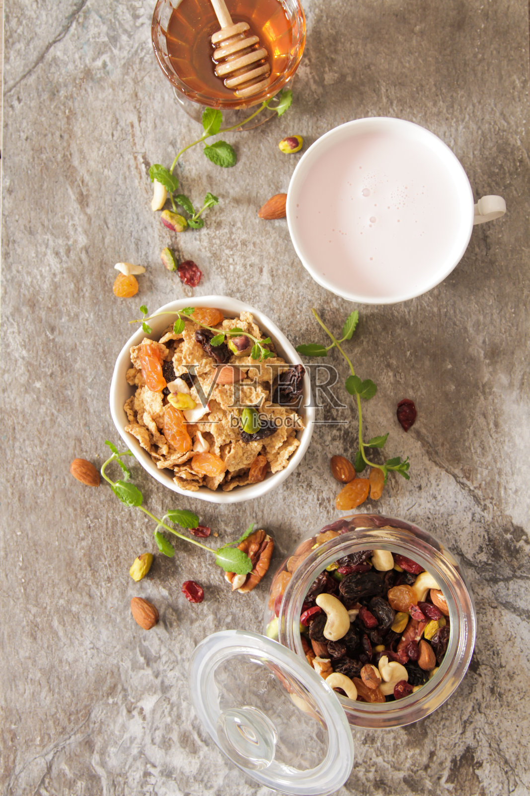 一杯加草莓牛奶和蜂蜜的什锦麦片照片摄影图片