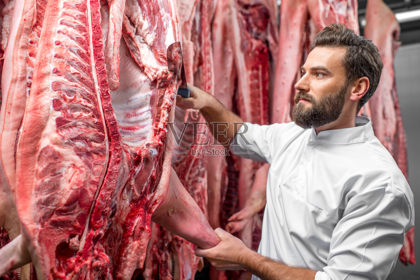在工厂切猪肉的屠夫照片摄影图片