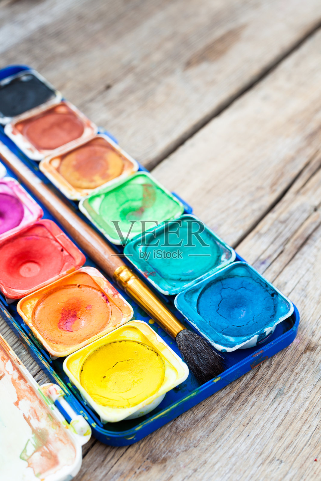 一套水彩颜料在木制背景上。照片摄影图片