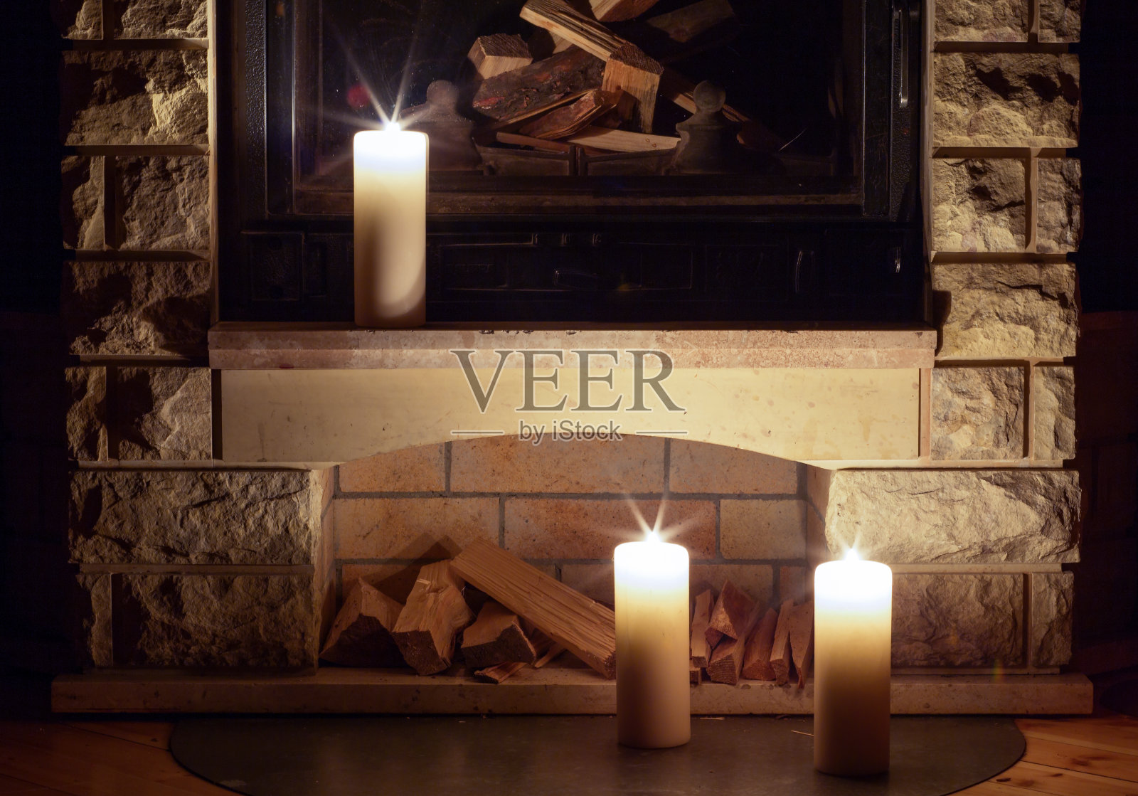 白色的大蜡烛立在壁炉上。照片摄影图片
