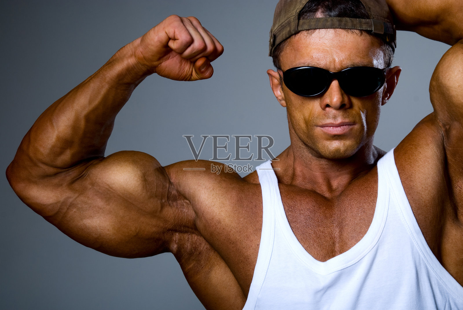 戴墨镜的壮汉露出他的肌肉照片摄影图片