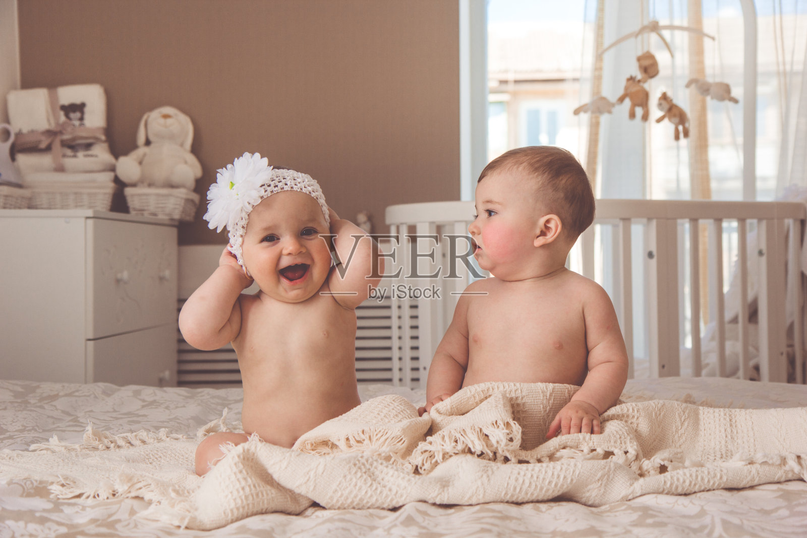 一对小男孩和小女孩在床上玩照片摄影图片