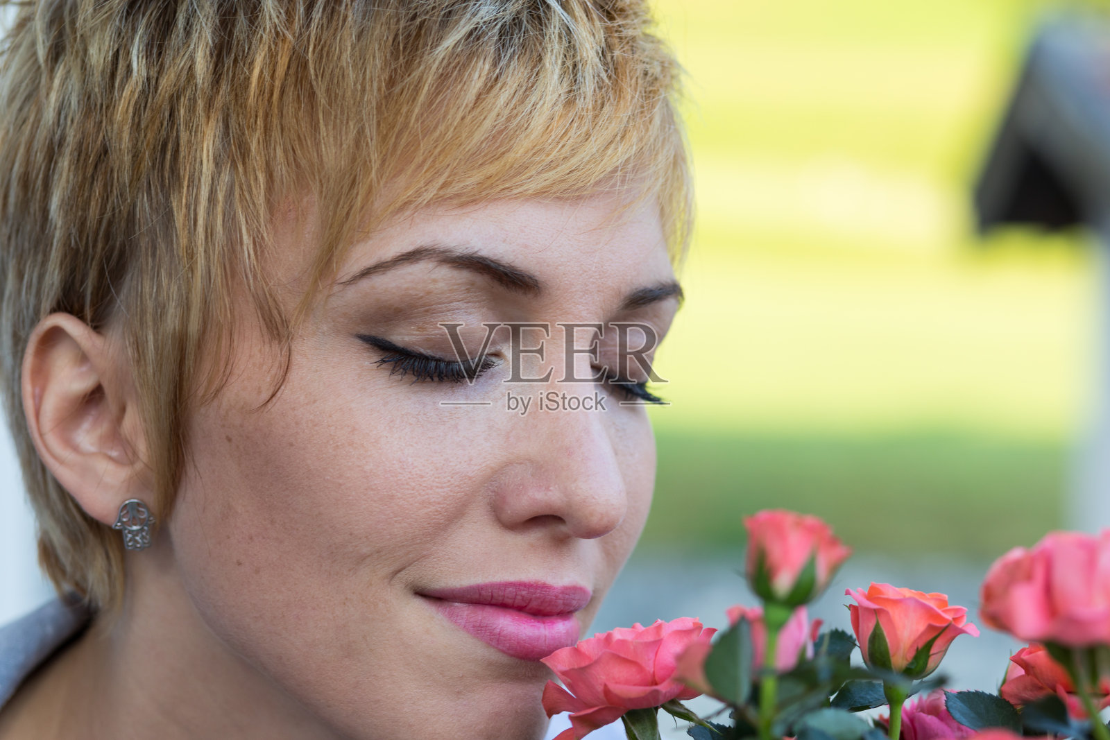 真正的女人在户外闻花照片摄影图片