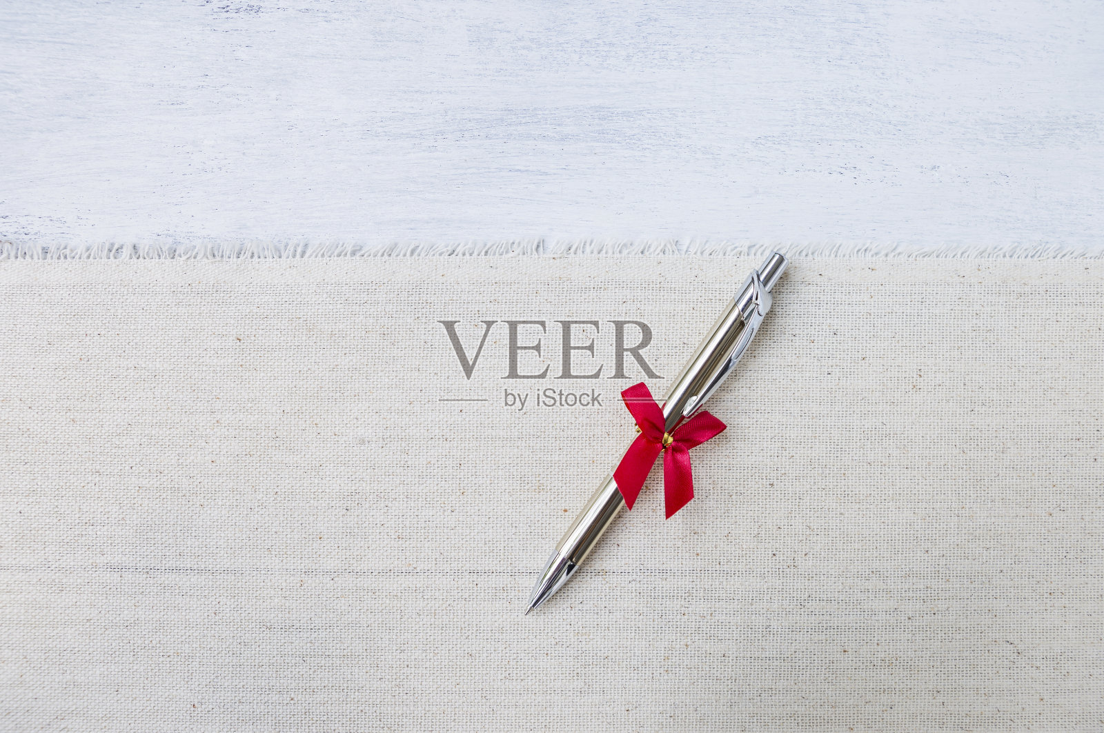 新的银色钢笔与红色丝带的帆布织物照片摄影图片