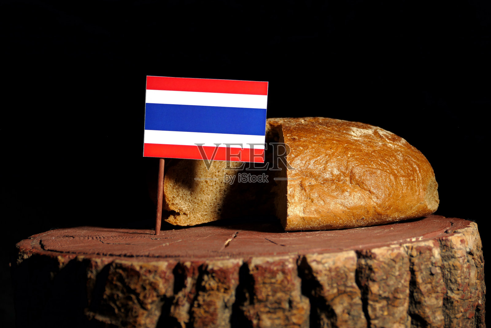 插在树桩上的泰国国旗和孤立的面包照片摄影图片