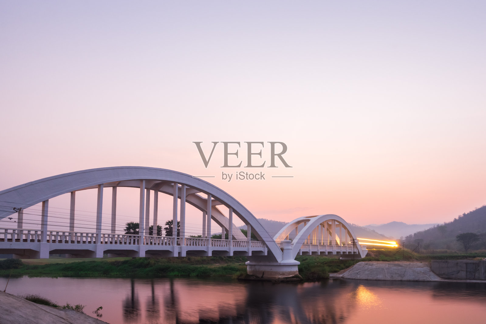 清晨的火车灯光照在兰芬的白色桥上。泰国照片摄影图片